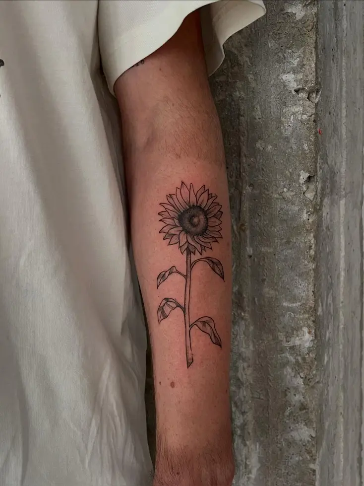 Tatuaje fine line de un girasol en la pantorrilla