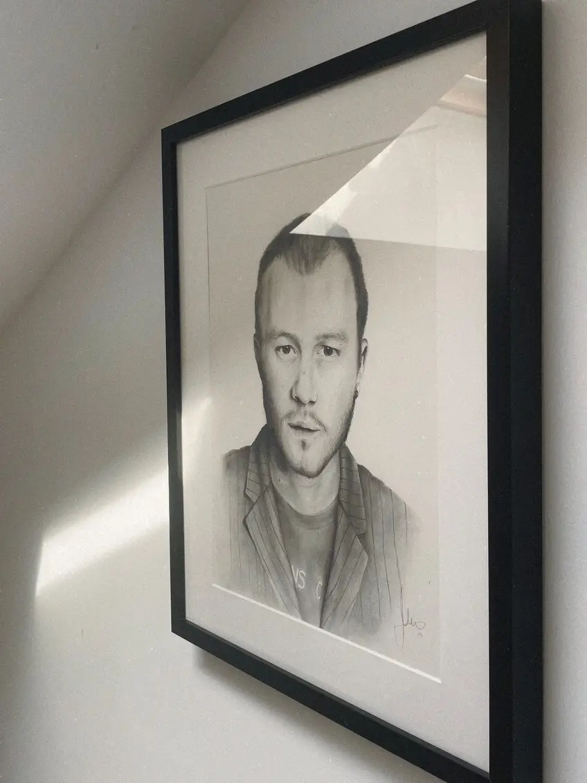 Retrato a lápiz enmarcado y colgado en la pared del estudio