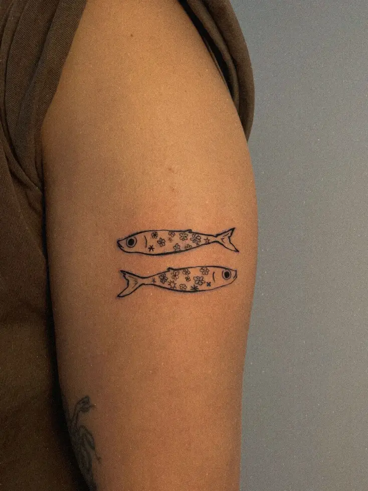 Tatuaje fine line de dos sardinas en el brazo
